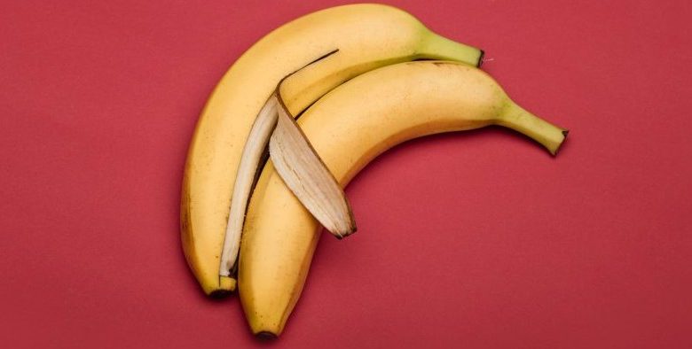 Two bananas hugging