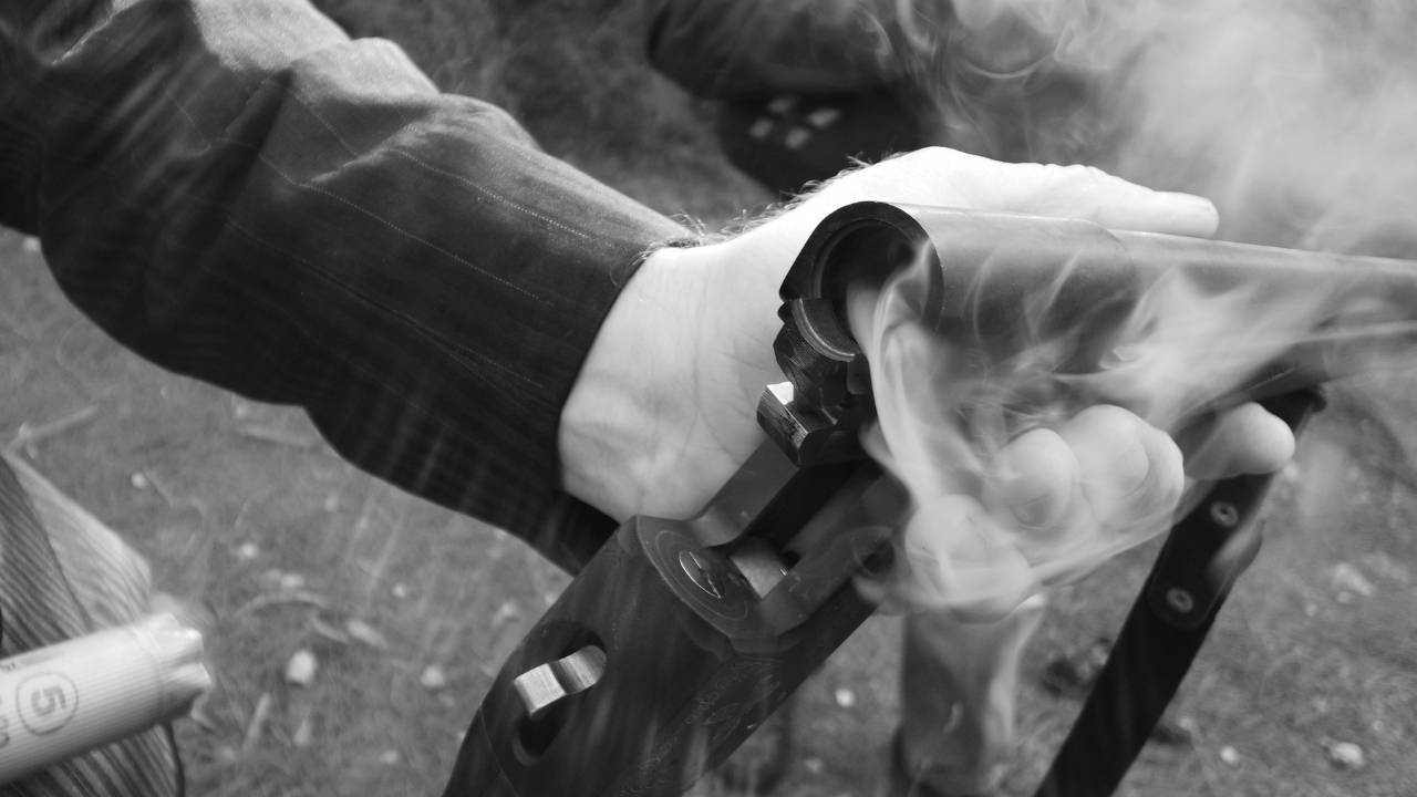 Person releasing shotgun shell on shotgun