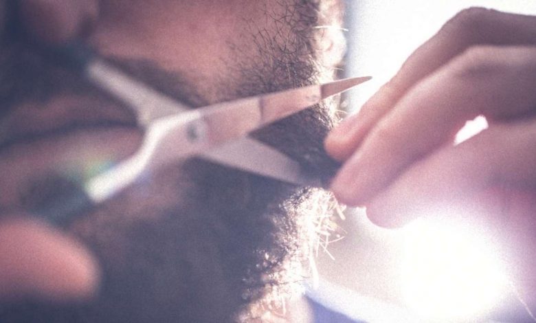A guy taking care of his beard
