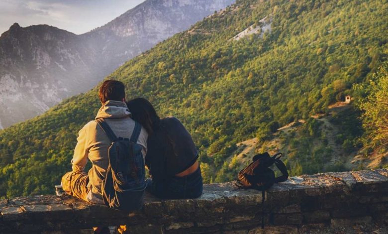 Couple sitting facing the mountains