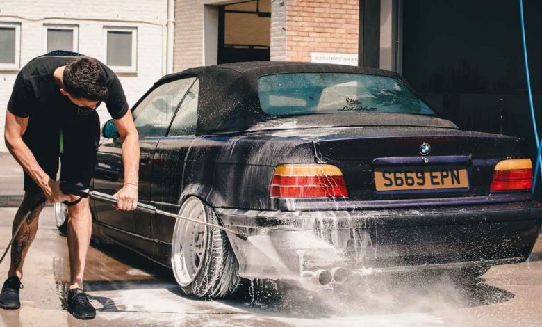 A guy washing his car with care