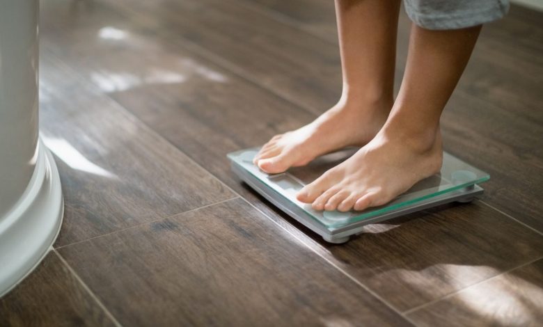 Boy checking his weight on weight scale