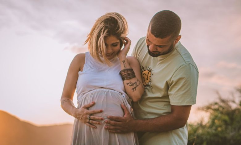 A man touching pregnant woman belly