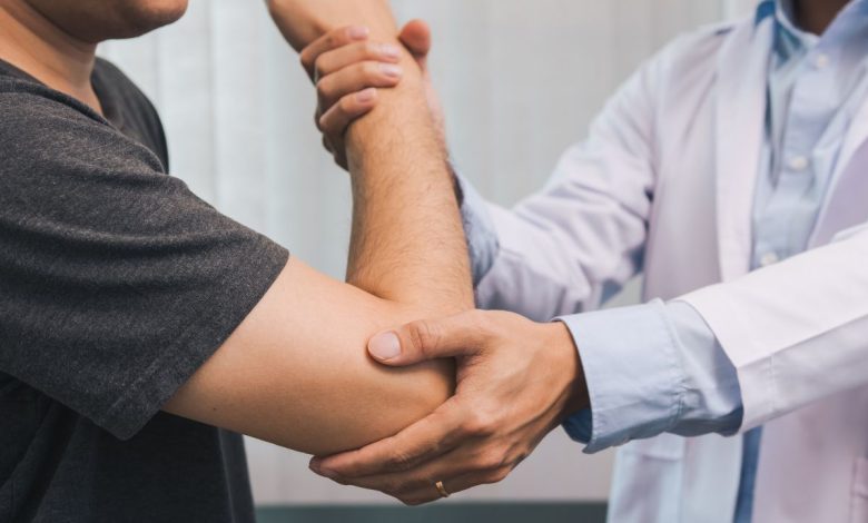 doctor checking a patients elbow