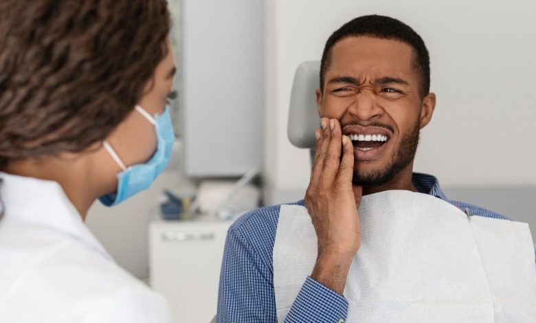 guy in dental chair suffering tooth pain