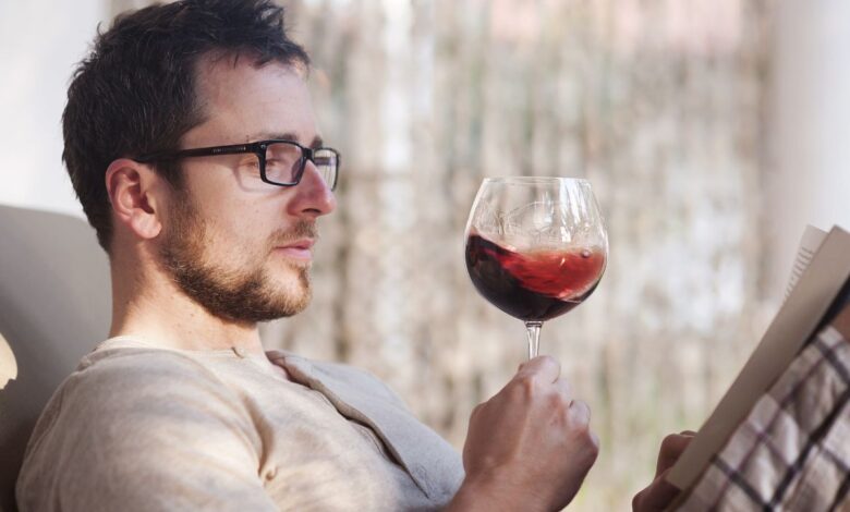 guy looking at wine glass