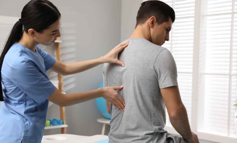 Doctor examining mans back
