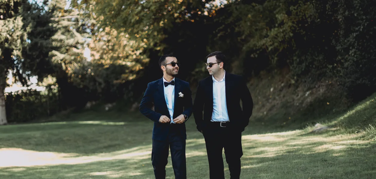 Groom and best man in suits walking outdoors before the wedding