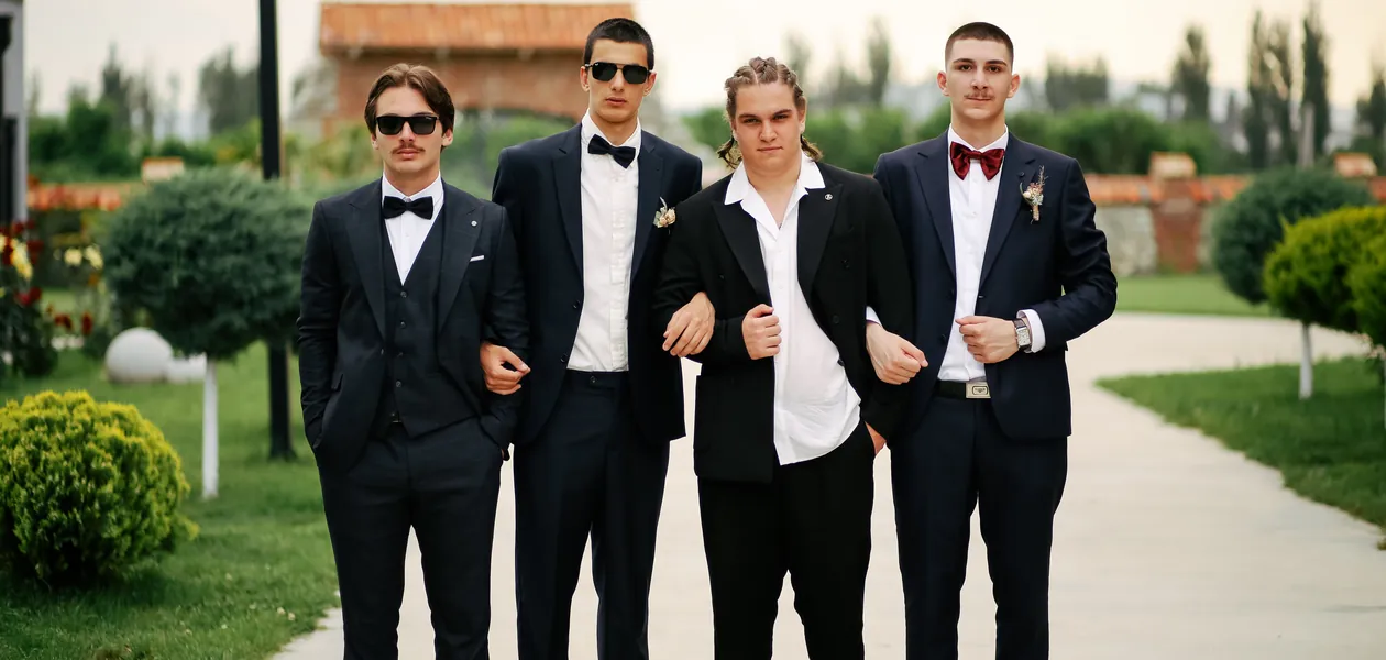 Groomsmen in suits posing outdoors before the wedding