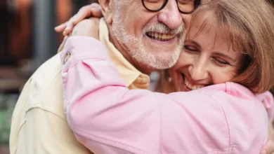 A joyful elderly couple sharing a warm embrace outdoors, exuding love and happiness.