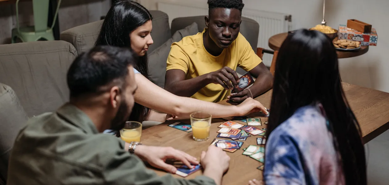 friends playing a card game with drinks