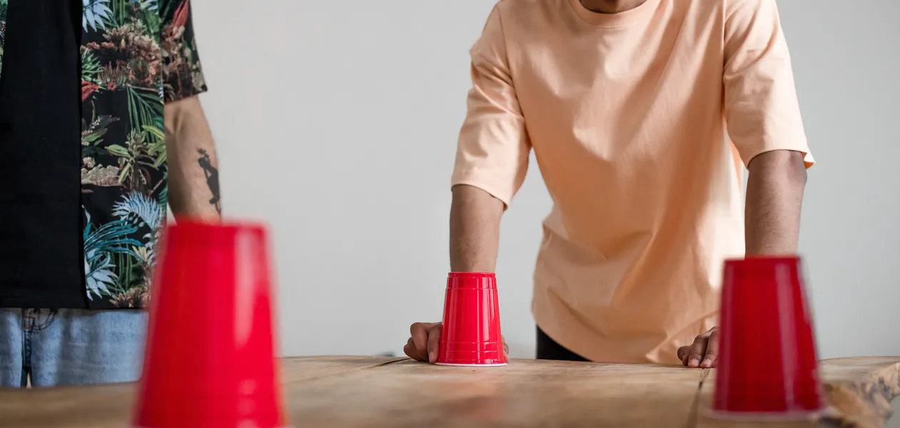 two men playing a red cup drinking game at a table