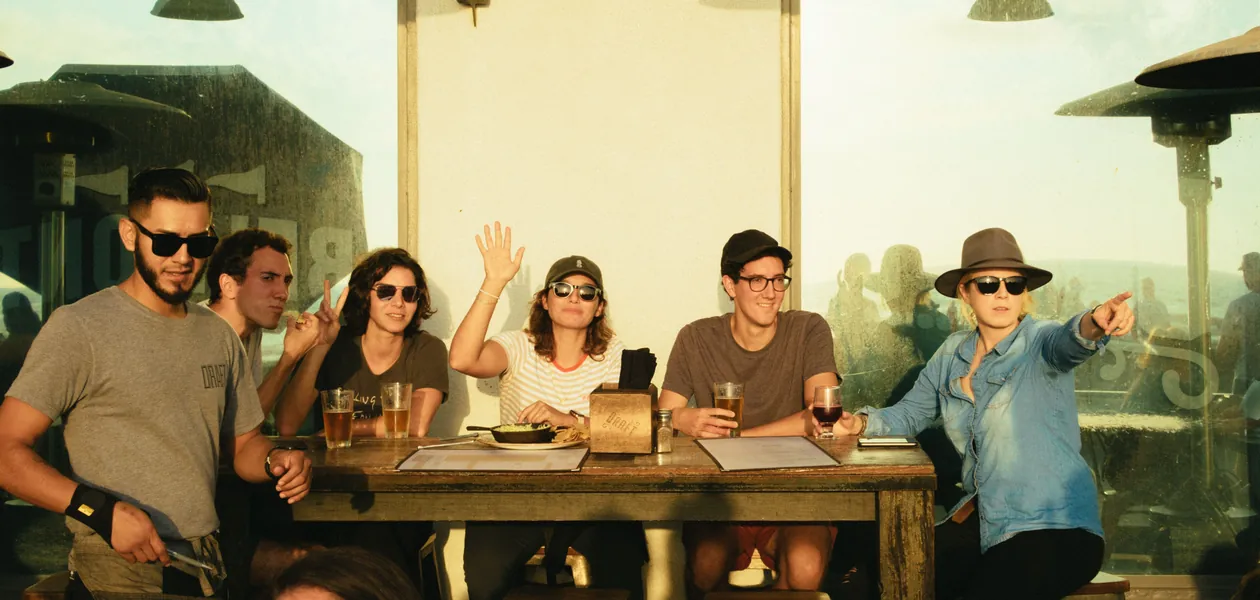 group of friends with drinks around an outdoor table