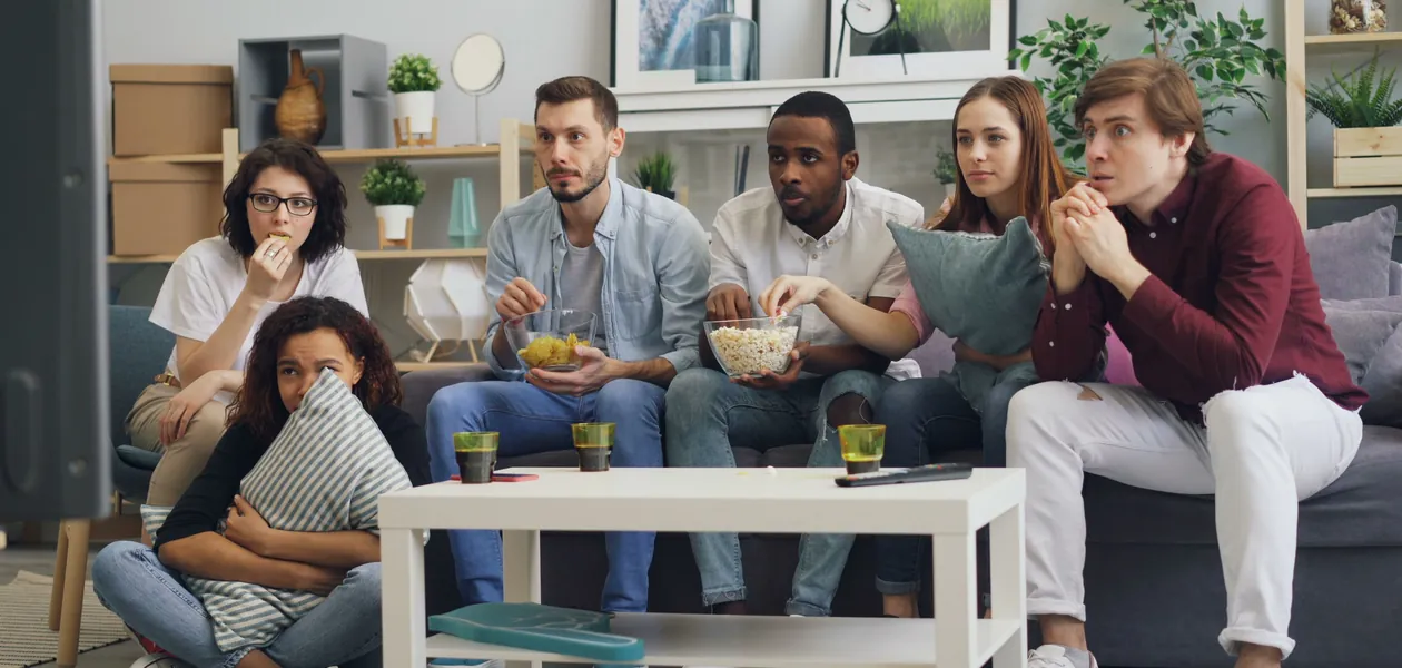 friends watching a movie on the couch with snacks and drinks