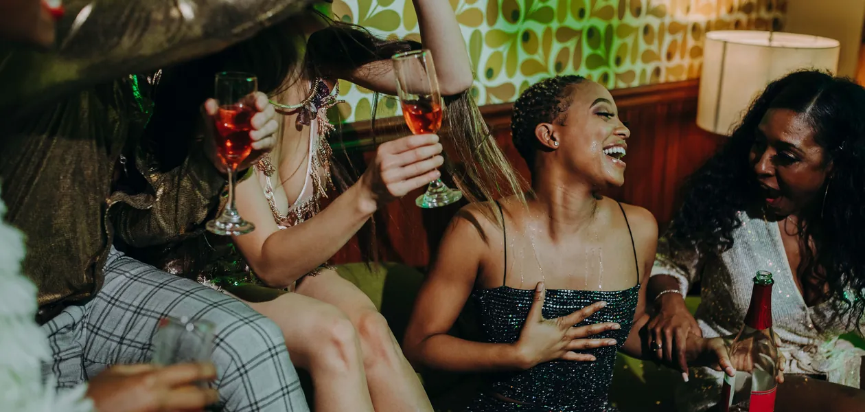 friends laughing over drinks at a house party