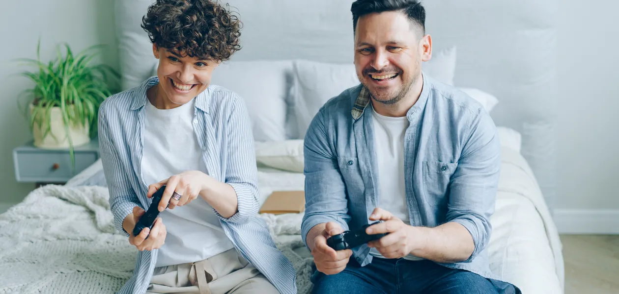 couple playing video games together in their bedroom