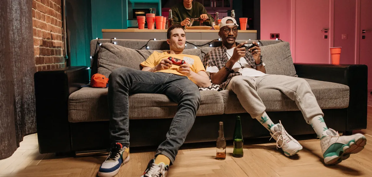 Group of friends playing video games together on the couch