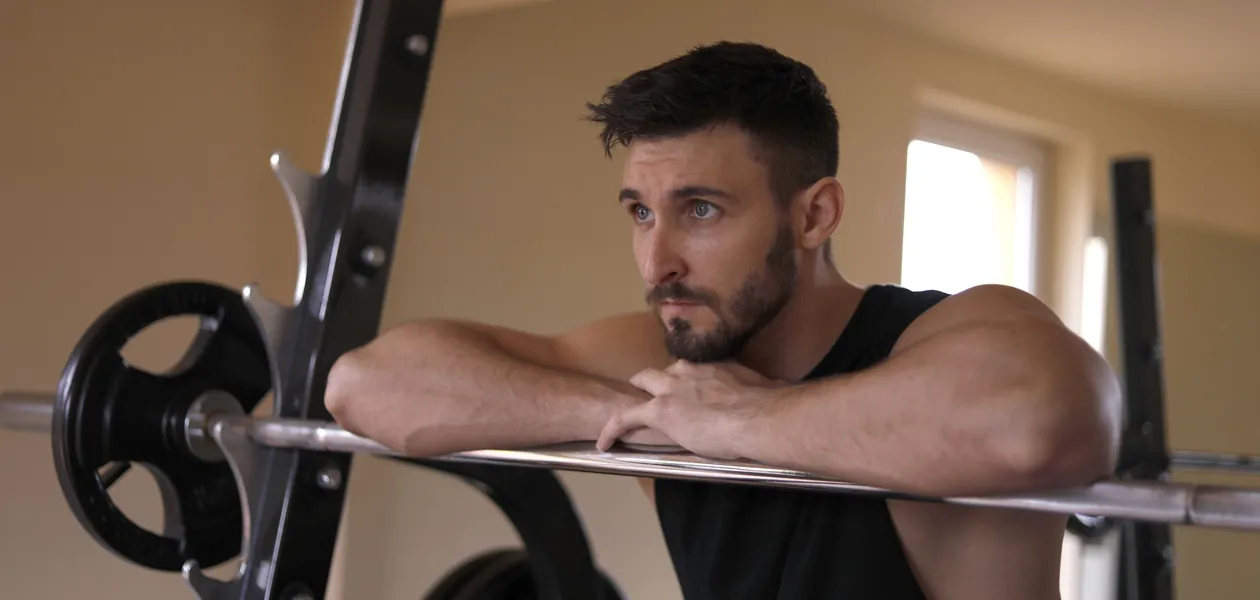 focused athlete resting between sets during his first workout back