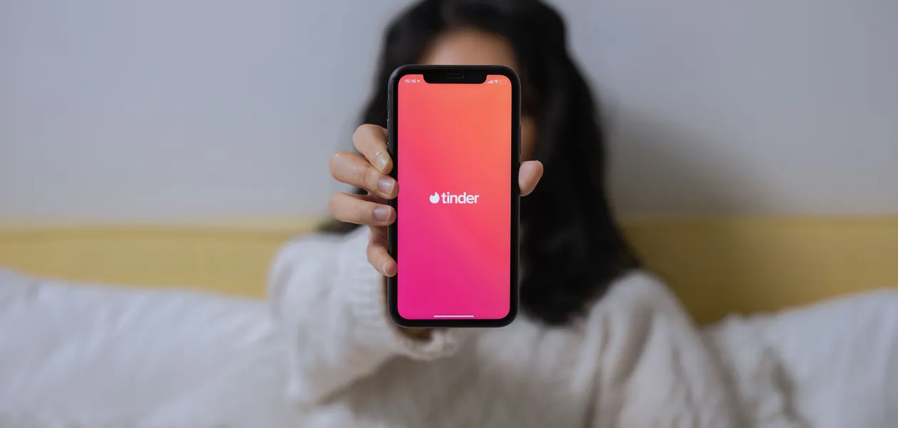 Woman showing the Tinder app on her smartphone