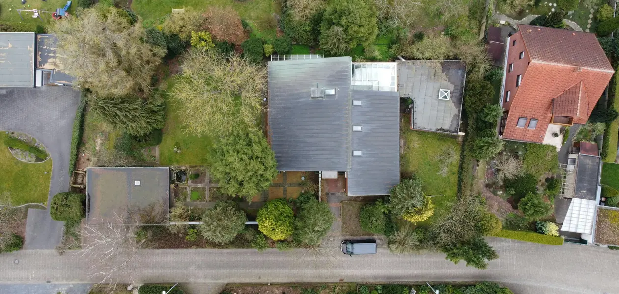 top-down view of suburban homes with lush gardens and green lawns