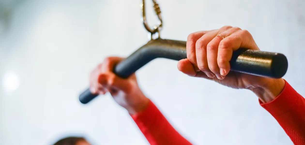 Close-up view of hands grasping a gym bar with focus on strength training and fitness.