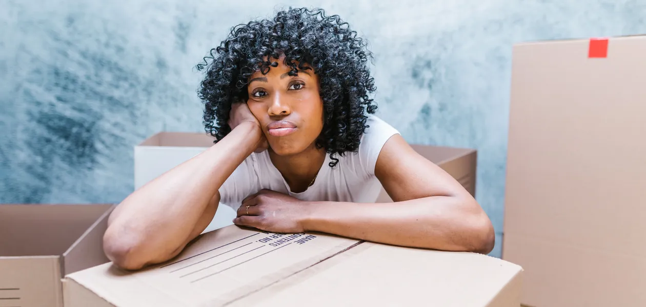 Woman packing a moving box before moving out of state for the first time