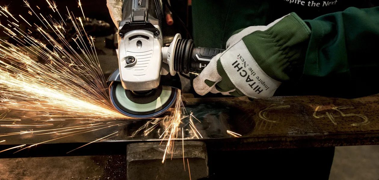 worker using an angle grinder with sparks flying, eye protection in use