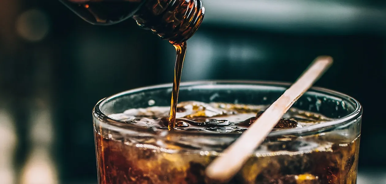 pouring simple syrup into an iced non-alcoholic drink