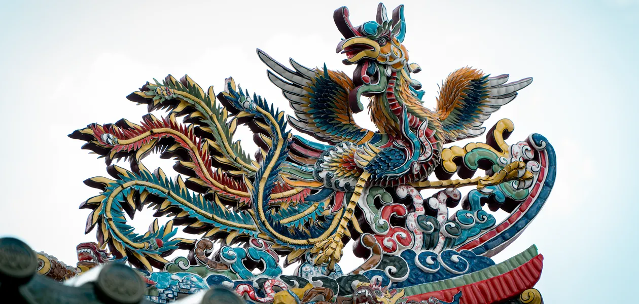 phoenix sculpture on a traditional roof