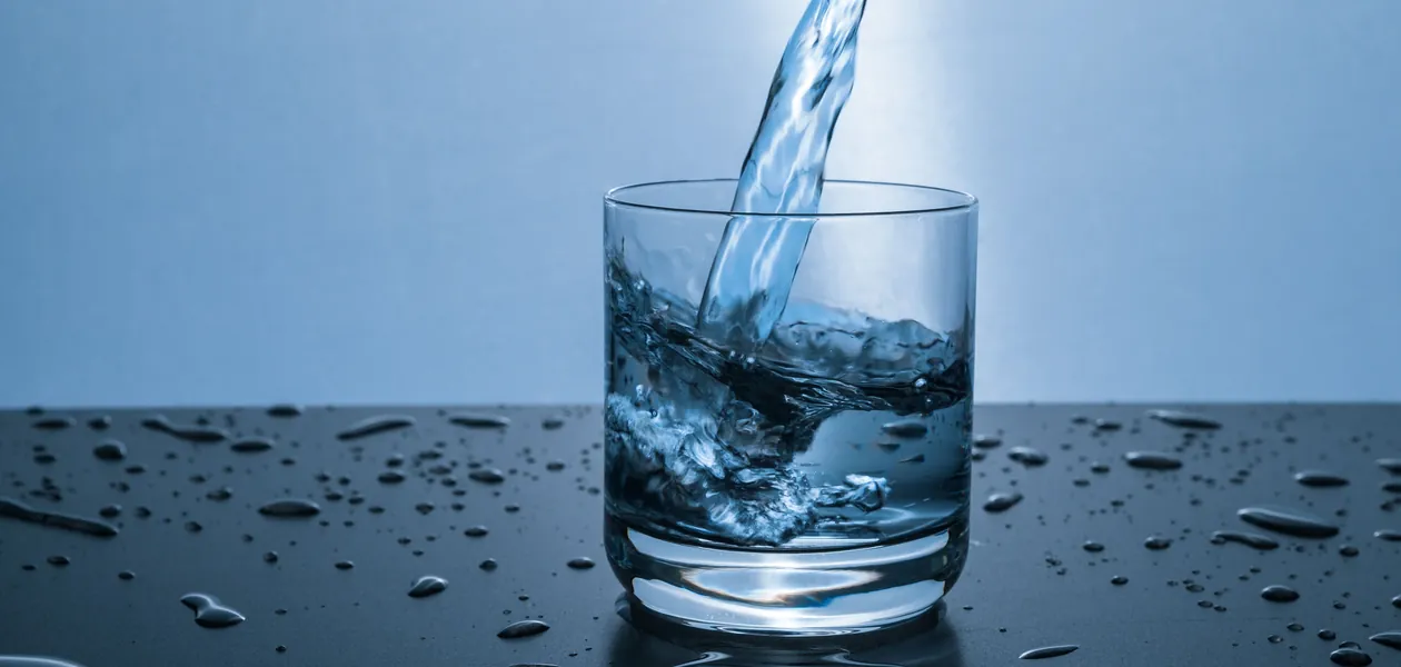 High-quality image of water being poured into a glass, illustrating hydration and purity.